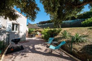 two chairs and a grill in a yard at Vista Mare in Porticcio