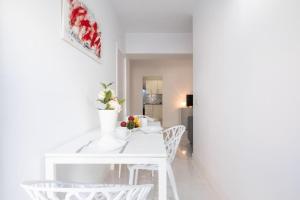 una sala da pranzo bianca con tavolo e sedie bianchi di Bubu Beach 1-A a Los Cristianos