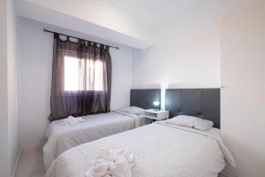 due letti in una stanza con finestra di Bubu Beach 1-A a Los Cristianos