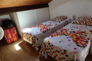 1 dormitorio con 2 camas individuales y colchas coloridas en Soulac l'Amélie - Maison à 300m de la plage, en Soulac-sur-Mer
