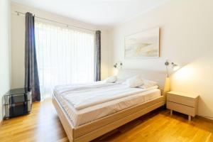 a bedroom with a bed and a large window at Daukanto Sun Apartment in Palanga