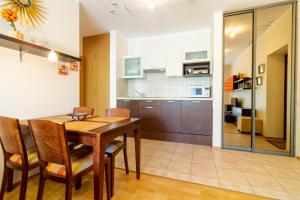 a kitchen and dining room with a wooden table and chairs at Daukanto Sun Apartment in Palanga