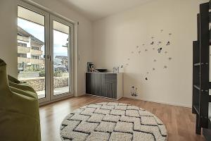 a living room with a large window and a rug at Sonnengarten Olivia in Garmisch-Partenkirchen