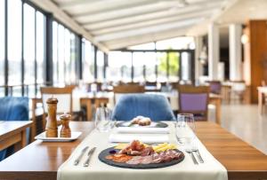 a table with a plate of food on top of it at Ribarska Koliba Resort in Pula