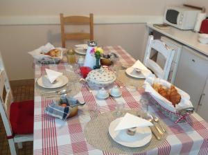 una tavola con un set da tavola con piatti e cibo di Maison Voie Verte a Bion