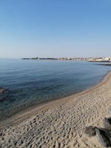 a beach with a rocky shoreline and the ocean at Sikelia home in Giardini Naxos