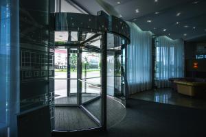 an open glass door in a building with a lobby at Hotel Mayak - Om Building in Omsk