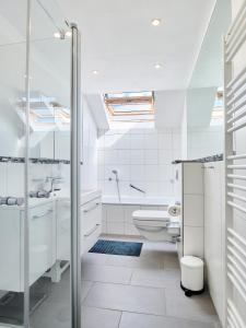 a white bathroom with a shower and a toilet at *80 m2 Stylish Apt* Netflix * Kitchen* Nespresso* in Wuppertal +10 photos