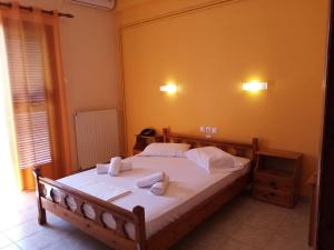 a bedroom with a bed with towels on it at Hotel Sevilli in Agios Ioannis Pelio