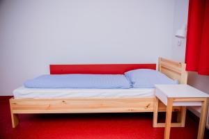 a bed sitting in a room next to a wall at Międzynarodowy Dom Spotkań Młodzieży w Oświęcimiu in Oświęcim
