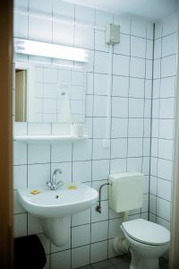a white toilet sitting next to a sink in a bathroom at Międzynarodowy Dom Spotkań Młodzieży w Oświęcimiu in Oświęcim