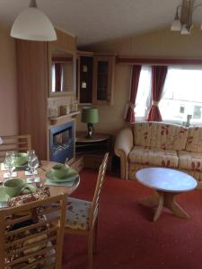 a living room with a table and a couch at Happy Days Holidays in Flamborough