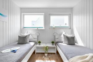 Habitación blanca con 2 camas y 2 ventanas en Sommer72, en Olpenitz
