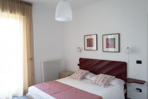 a bedroom with a bed with two pillows on it at Luisella Apartments in Albenga