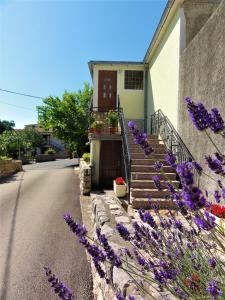 ein Haus mit lila Blumen davor in der Unterkunft Apartment Mira Šilo-Krk in Šilo