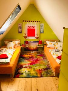 two beds in a attic room with a rug at Appartment Ivonete in Wettringen