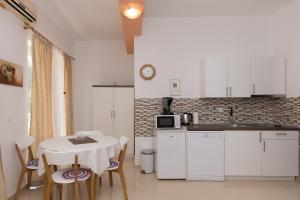 a kitchen with a table and a white kitchen at Apartments Lovrić in Vodice