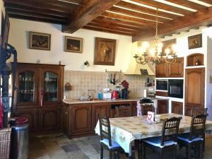 a kitchen with a table and chairs in a room at Grande et belle demeure in Prez-sous-Lafauche