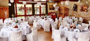 une pièce remplie de tables et de chaises blanches dans l'établissement Hotel Neue Höhe, à Klingenberg