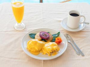 un plato de comida con huevos y una taza de zumo de naranja en Capital O Hotel Posada Terraza, Tequila Jalisco en Tequila
