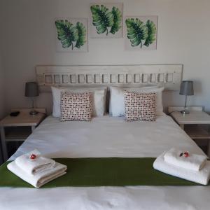 a bedroom with a bed with towels on it at OCEAN VIEW GUEST HOUSE in Jeffreys Bay