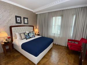 イスタンブールにあるFour Doors Hotelのベッドルーム1室(大型ベッド1台、赤い椅子付)