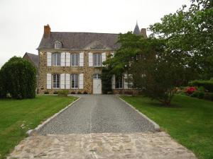 uma grande casa de pedra com uma entrada em Manoir familial de la Provosterie em Ahuillé