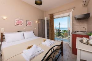 a bedroom with a bed and a kitchen with a balcony at Dimitreli Eleni Studios in Koinyra
