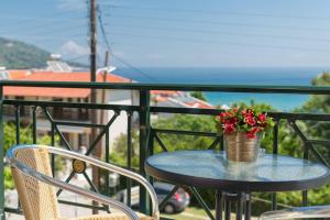 a table with a vase of flowers on a balcony at Dimitreli Eleni Studios in Koinyra