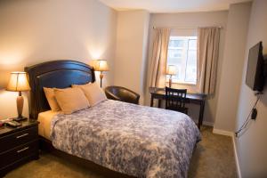 ein Hotelzimmer mit einem Bett, einem Schreibtisch und einem Fenster in der Unterkunft Downtown Whitehorse 4 bedrooms deluxe condo in Whitehorse