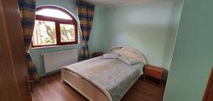 a bedroom with a bed in a room with a window at Vila Vasile in Mamaia Sat/Năvodari