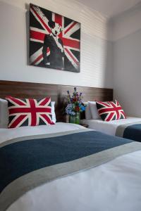 two beds in a hotel room with british flags on the wall at New Steine Hotel - B&B in Brighton & Hove