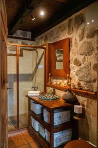 Santa María la Real de NievaにあるLA CASA DEL BUHOの石造りのバスルーム(シンク、シャワー付)