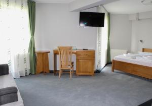 Dormitorio con escritorio, cama y TV en Hostel Teleki, en Sovata
