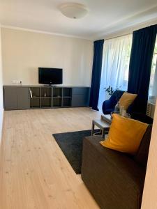 een woonkamer met een bank en een flatscreen-tv bij Centro Apartamentai in Zarasai