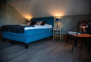 a bedroom with a blue bed and a side table at Villa Göta in Forsvik