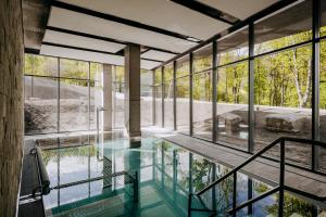 a house with a pool and glass walls at Radisson Hotel Szklarska Poręba in Szklarska Poręba