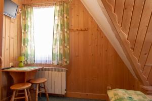 ein Zimmer mit einem Bett, einem Schreibtisch und einem Fenster in der Unterkunft MC82 - Anna Łukaszczyk in Małe Ciche