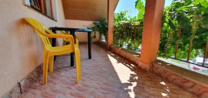 a table and a yellow chair on a balcony at Vila Vasile in Mamaia Sat/Năvodari +30 photos