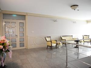 a room with chairs and a table and flowers at Hotel Dacia Sud in Mamaia