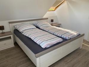 1 cama con 2 almohadas en una habitación en Traumhafte Dachgeschosswohnung, en Königslutter am Elm