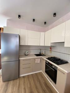 a kitchen with white cabinets and a stainless steel refrigerator at Сдам дом у моря (новый дом) 9-ая Фонтана in Odesa