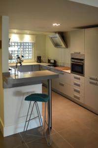eine Küche mit einer Theke und einem Hocker darin in der Unterkunft Alcazaba Beach Luxury Apartment02 Estepona in Estepona