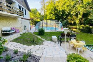 a patio with a table and chairs and a pool at Villas-des-eaux Douces in Marsac