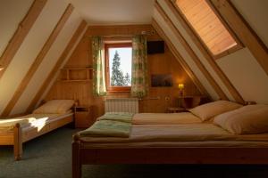 2 Betten in einem Dachzimmer mit Fenster in der Unterkunft MC82 - Anna Łukaszczyk in Małe Ciche