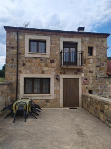 a stone house with a bench in front of it at La Laguna in Hinojosa de la Sierra