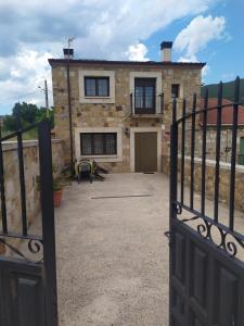 an open gate to a stone house with a patio at La Laguna in Hinojosa de la Sierra