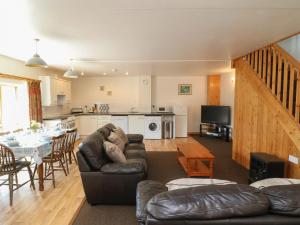 a living room with a couch and a table at The Dairy in Bude +16 photos