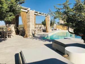 een villa met een zwembad en een patio bij Milo Milo Suites in Mandrakia