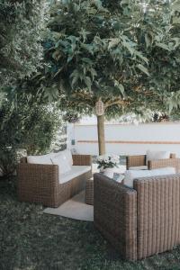 two wicker chairs and a table under a tree at Chez Angel in Varennes-sur-Morge